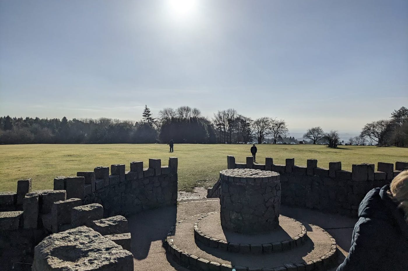 a stone structure in a grassy field