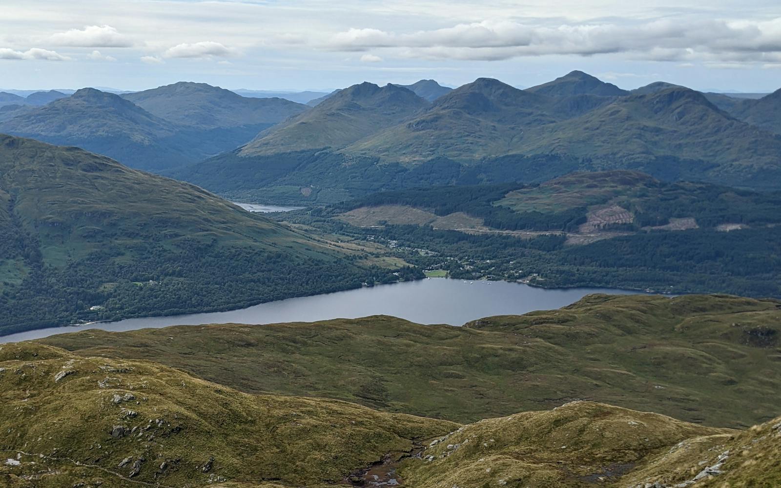 A scenic vista of a lake nestled amidst a dramatic mountain range