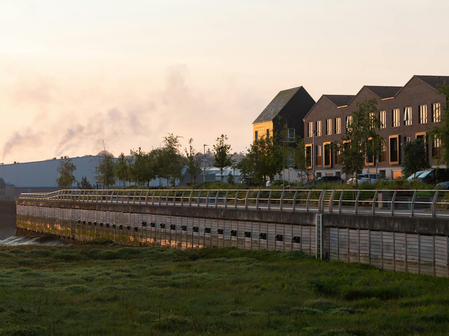 A row of houses and cars next to a river