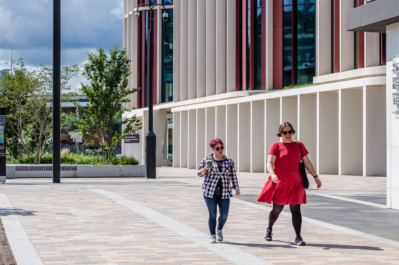 two women walking on a brick walkway