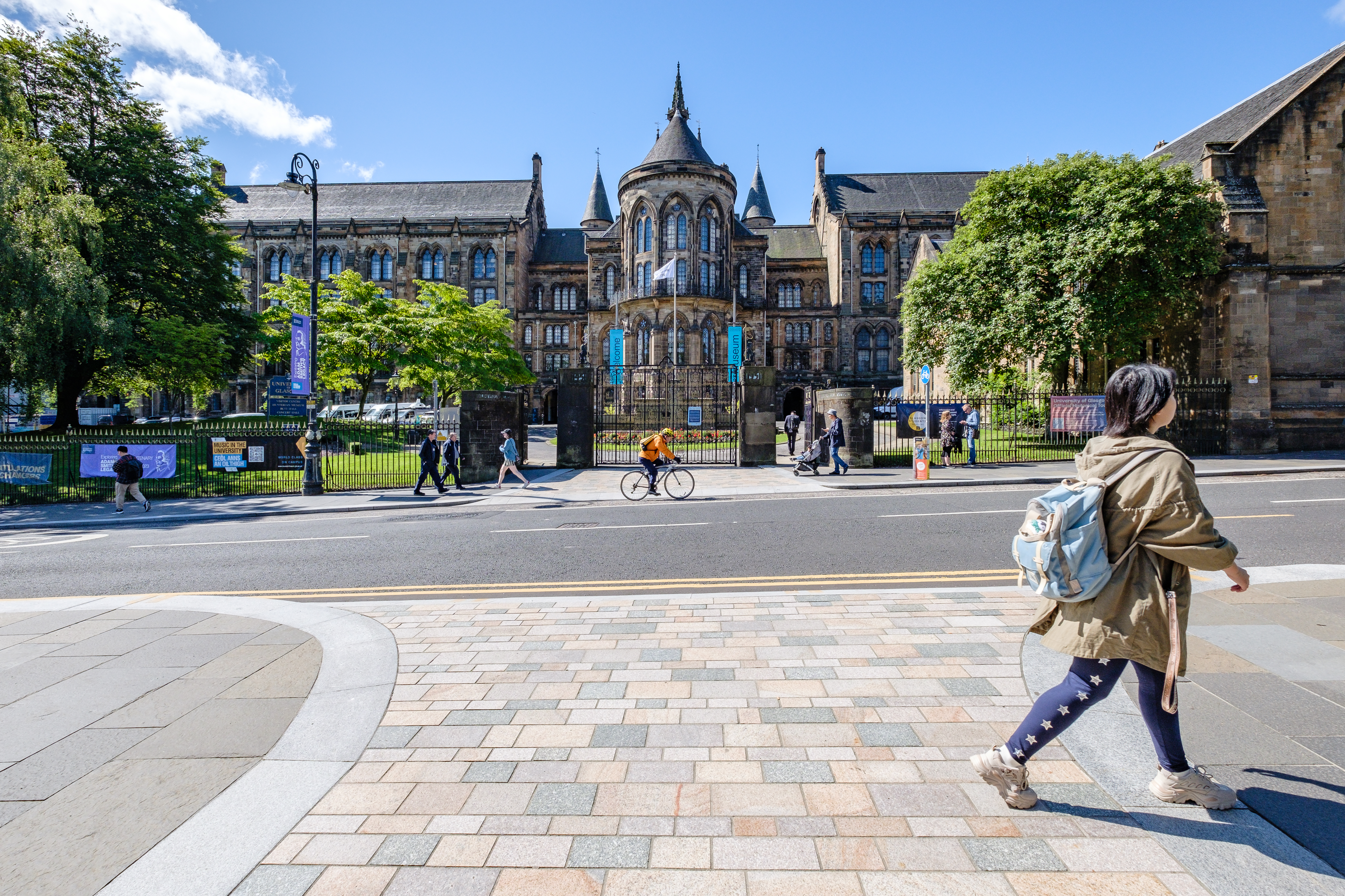 a woman walking on a pavement in front of a large building