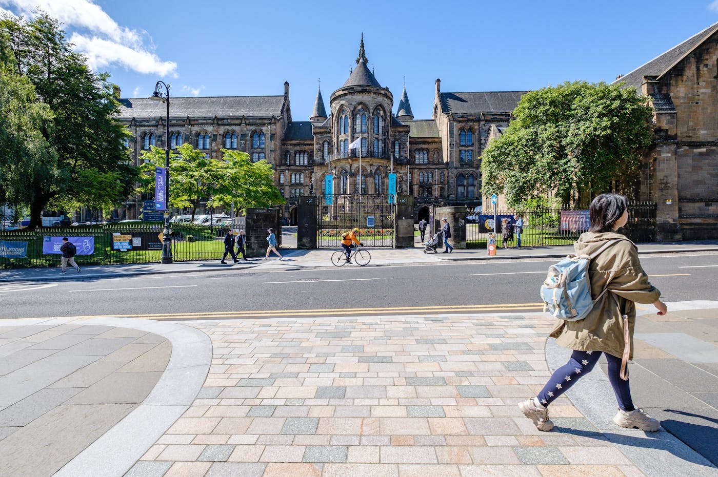 a woman walking on a pavement in front of a large building