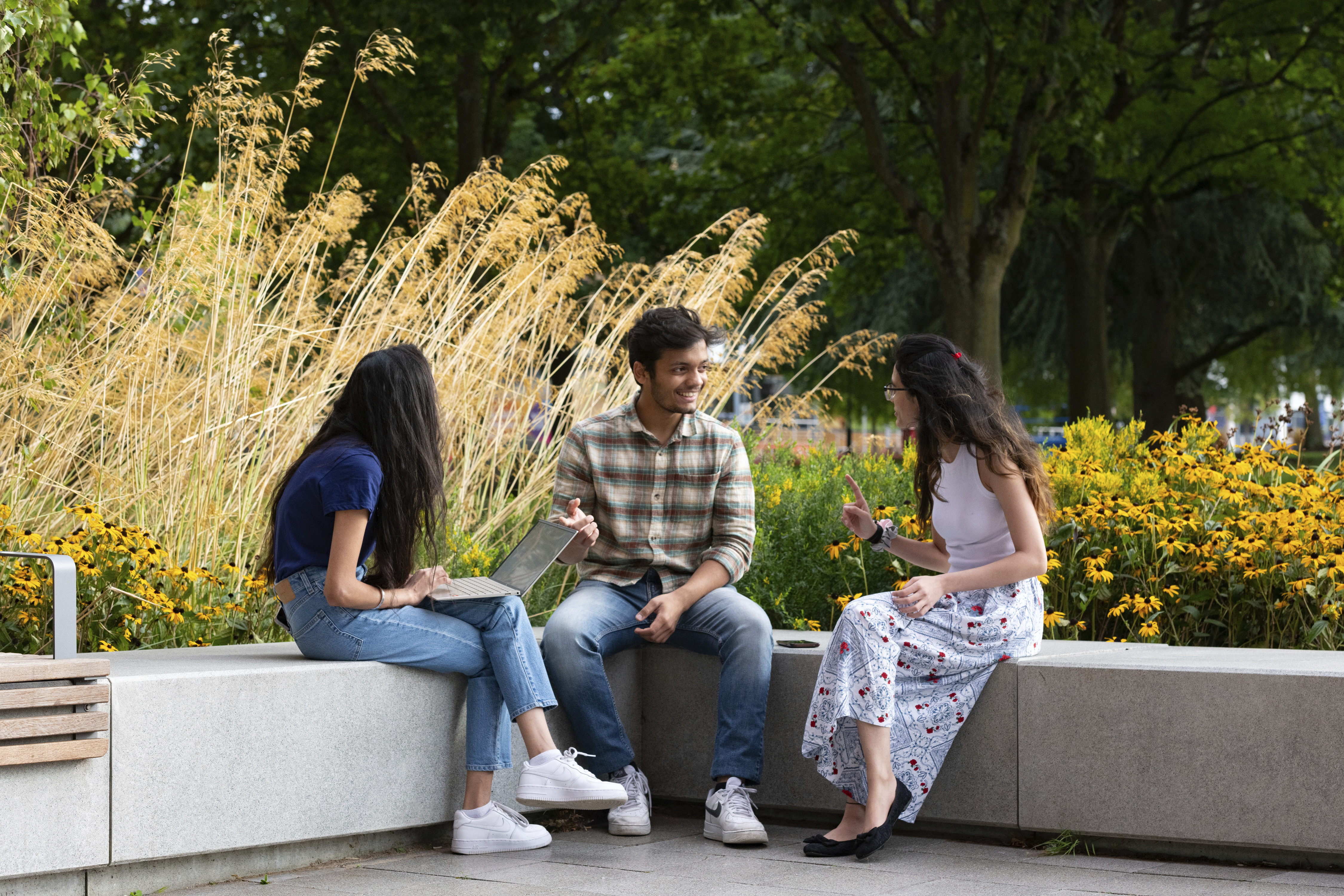 a group of people sitting on a stone bench