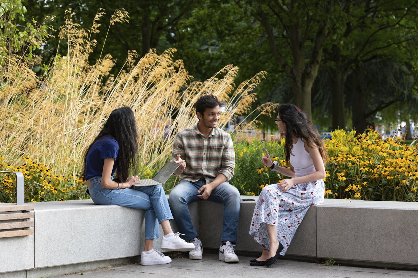 a group of people sitting on a stone bench