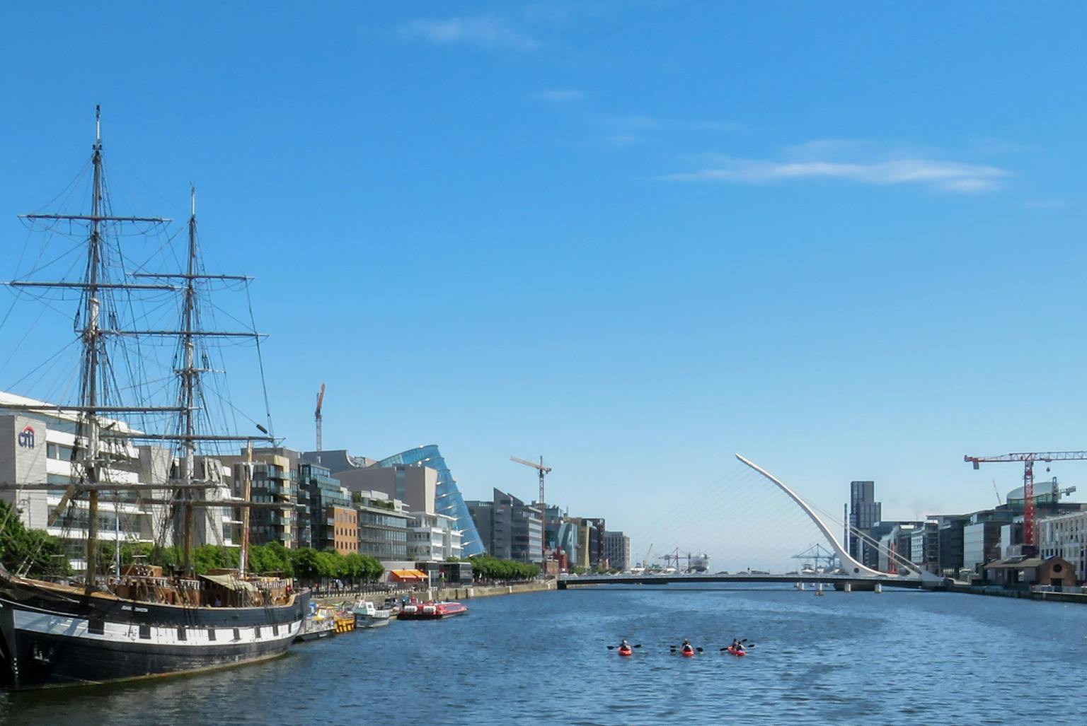 The Jeanie Johnston, a tall ship replica from the Irish Famine, docked in a picturesque harbor