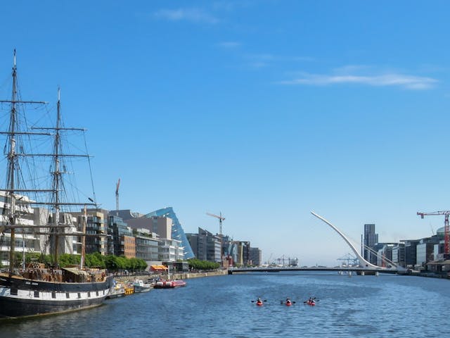 The Jeanie Johnston, a tall ship replica from the Irish Famine, docked in a picturesque harbor