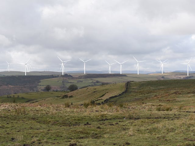Wind turbines on a hill generating clean, renewable energy