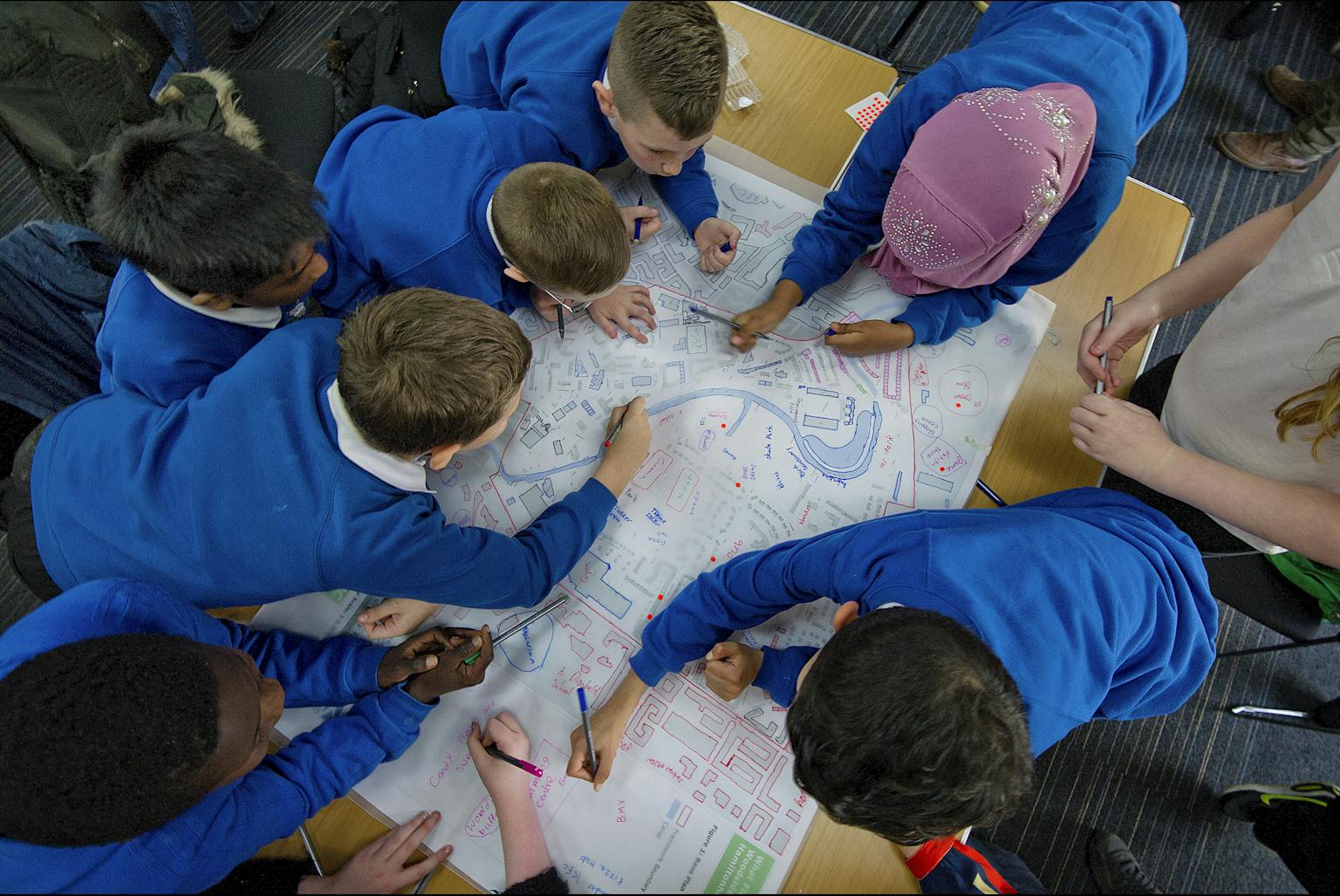 School children drawing on map