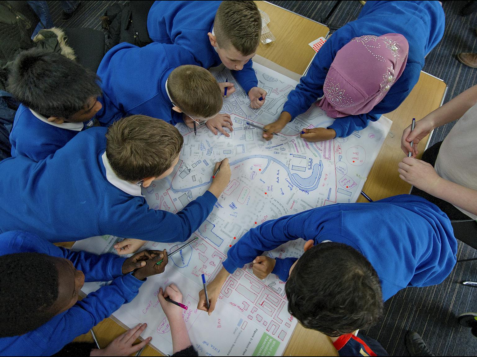 School children drawing on map