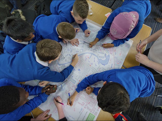 School children drawing on map