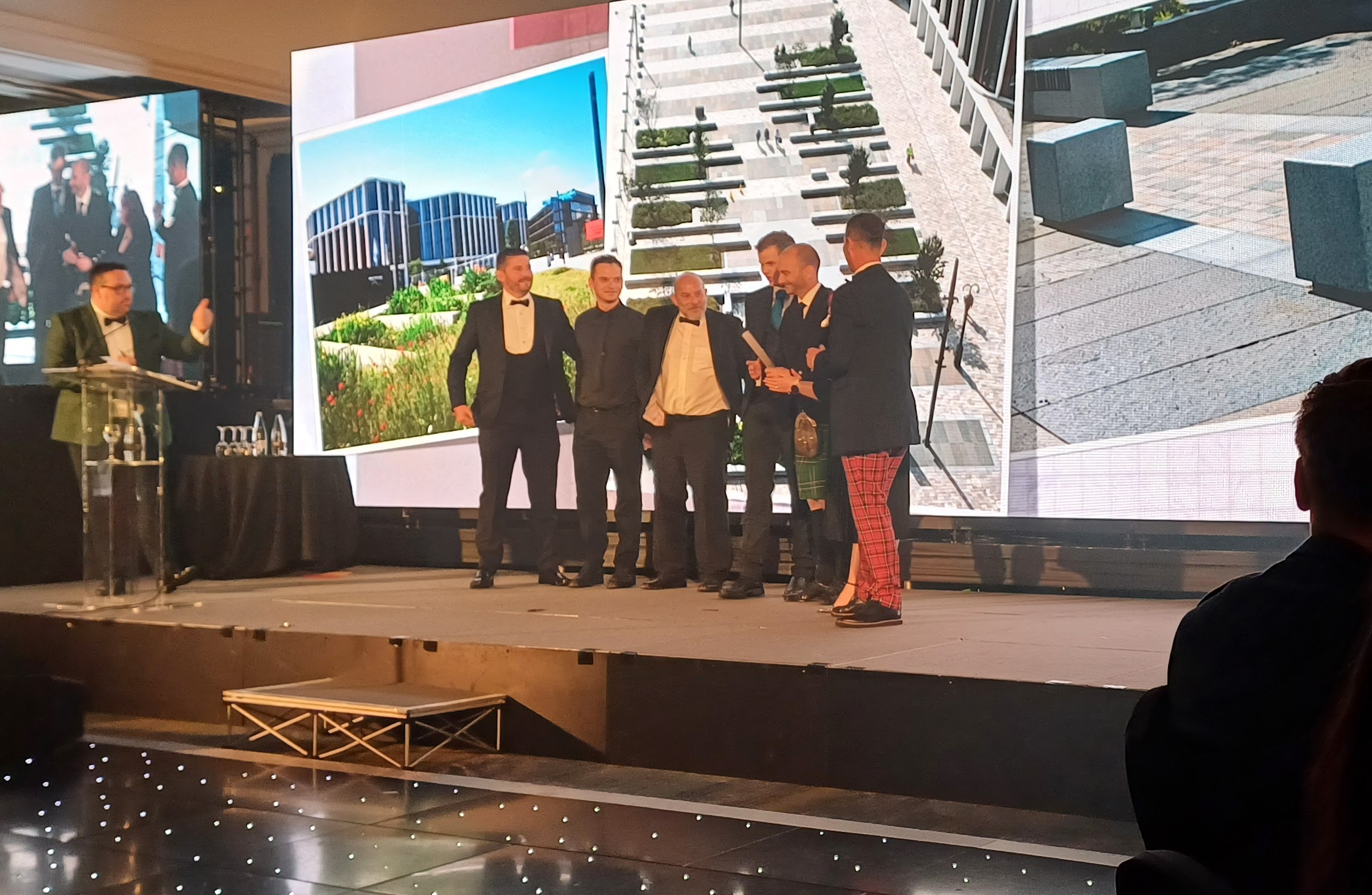 Group of people standing on stage accepting award