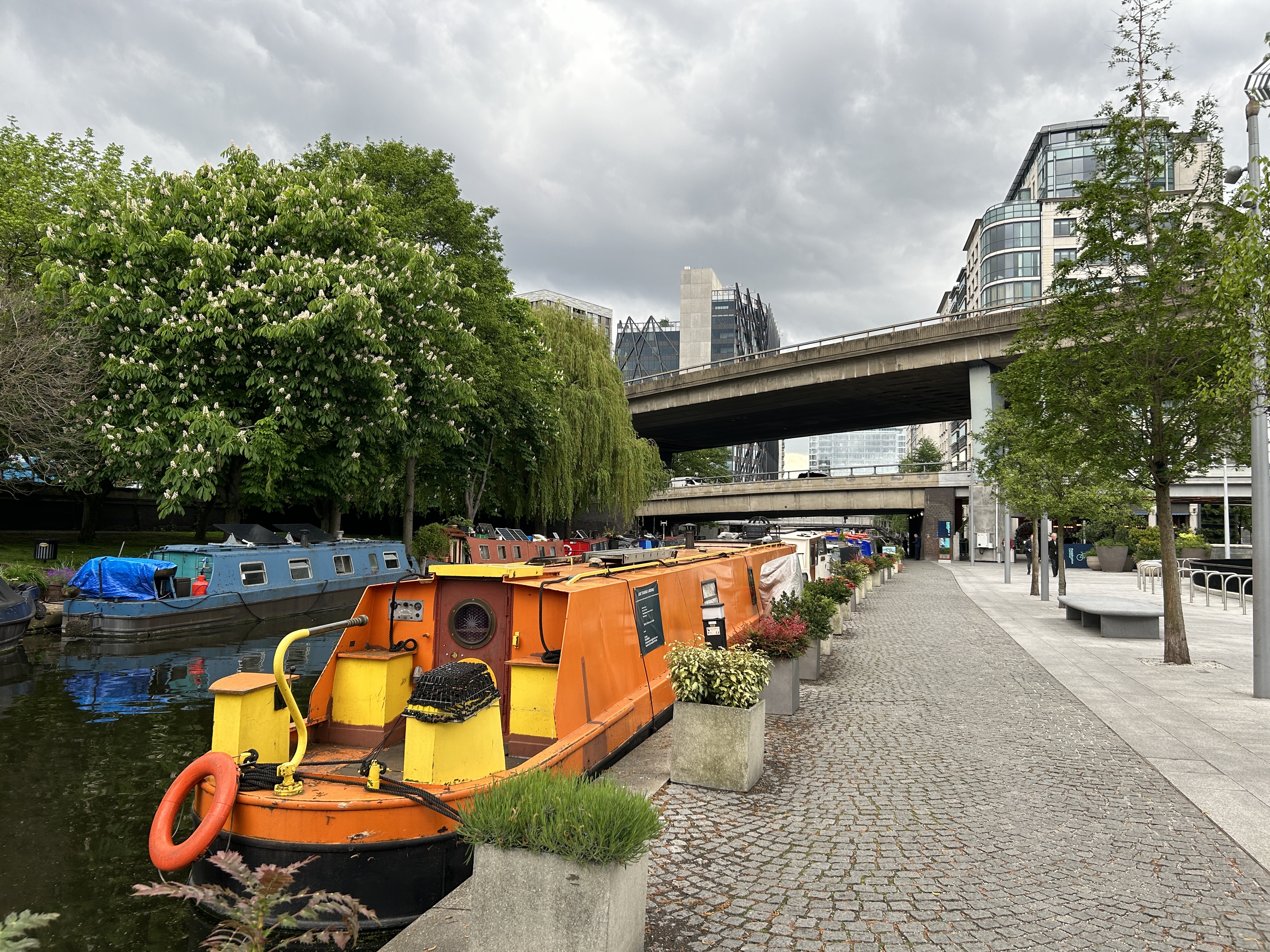 A canal with canal boats and city buildings in the background