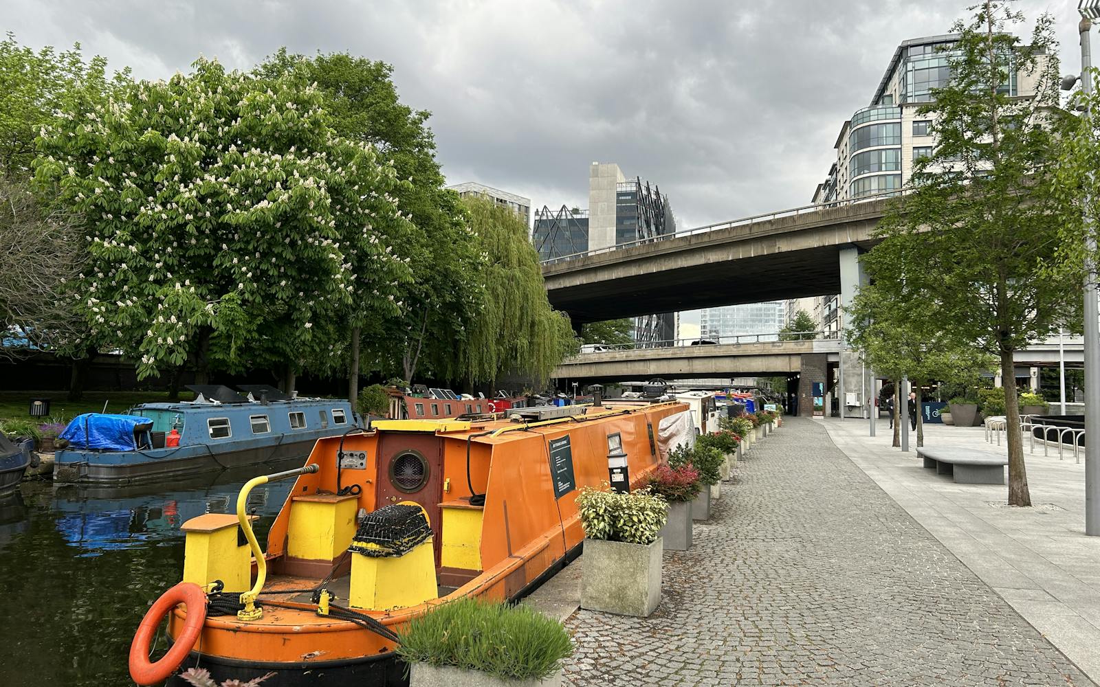 A canal with canal boats and city buildings in the background