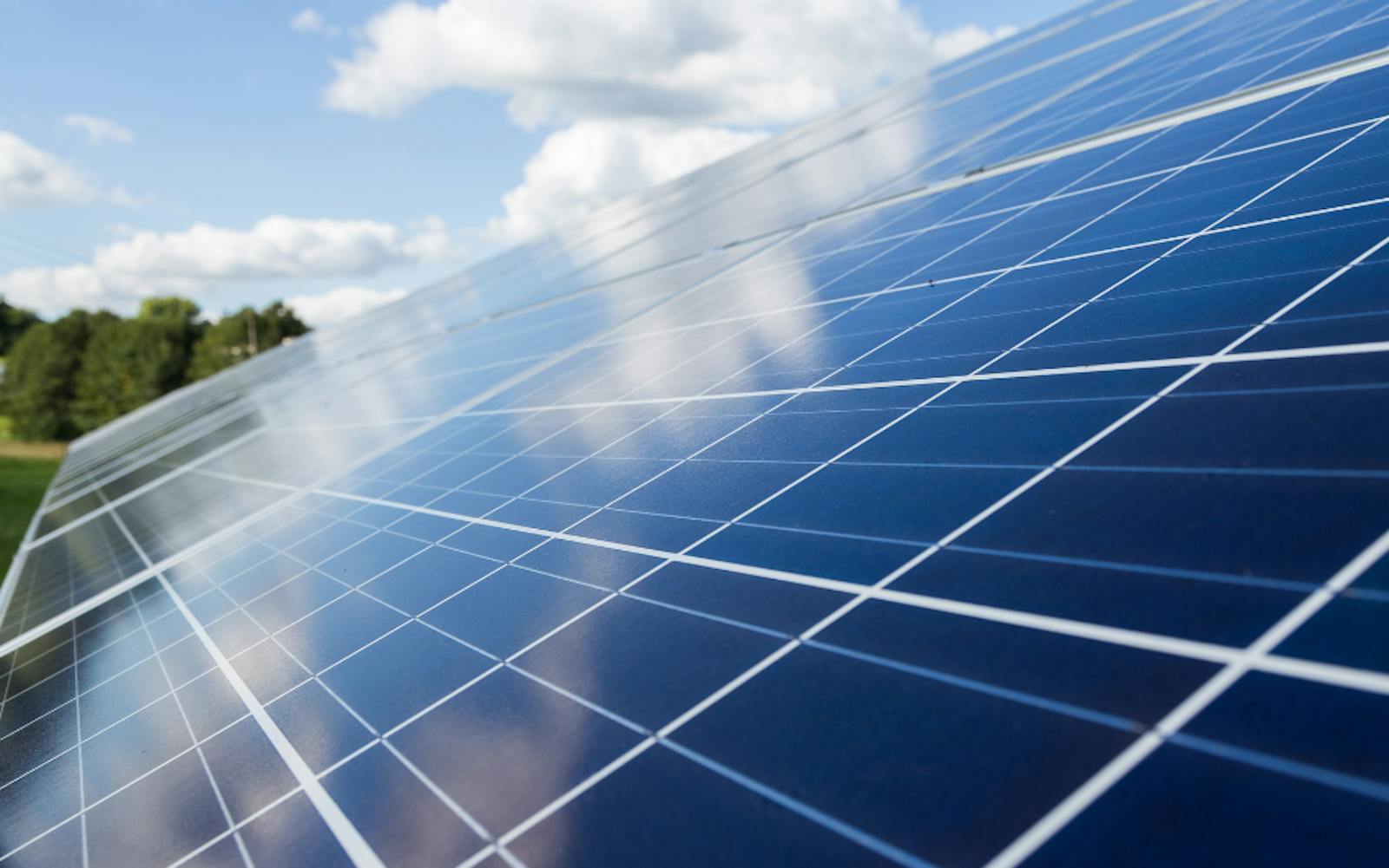 solar panel reflecting a blue sky with clouds