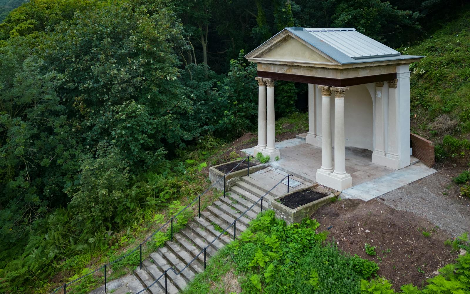 Memorial building on hill amongst woodland