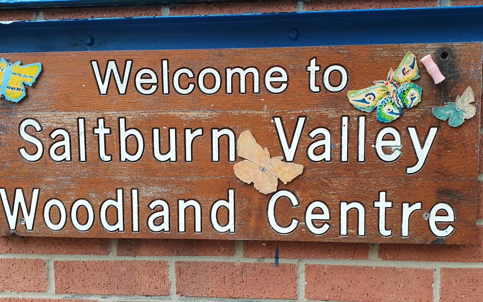 Welcome sign attached to brick wall
