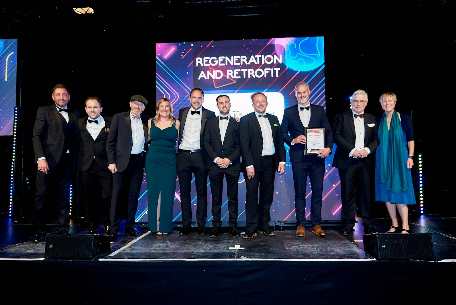 Group of people standing on stage accepting award