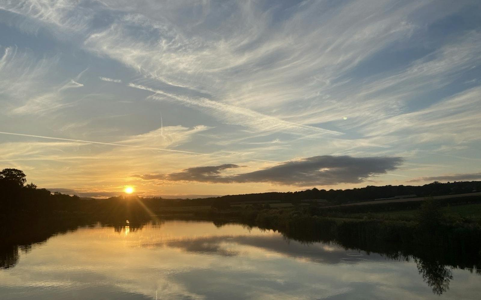 The sun sets over a body of water
