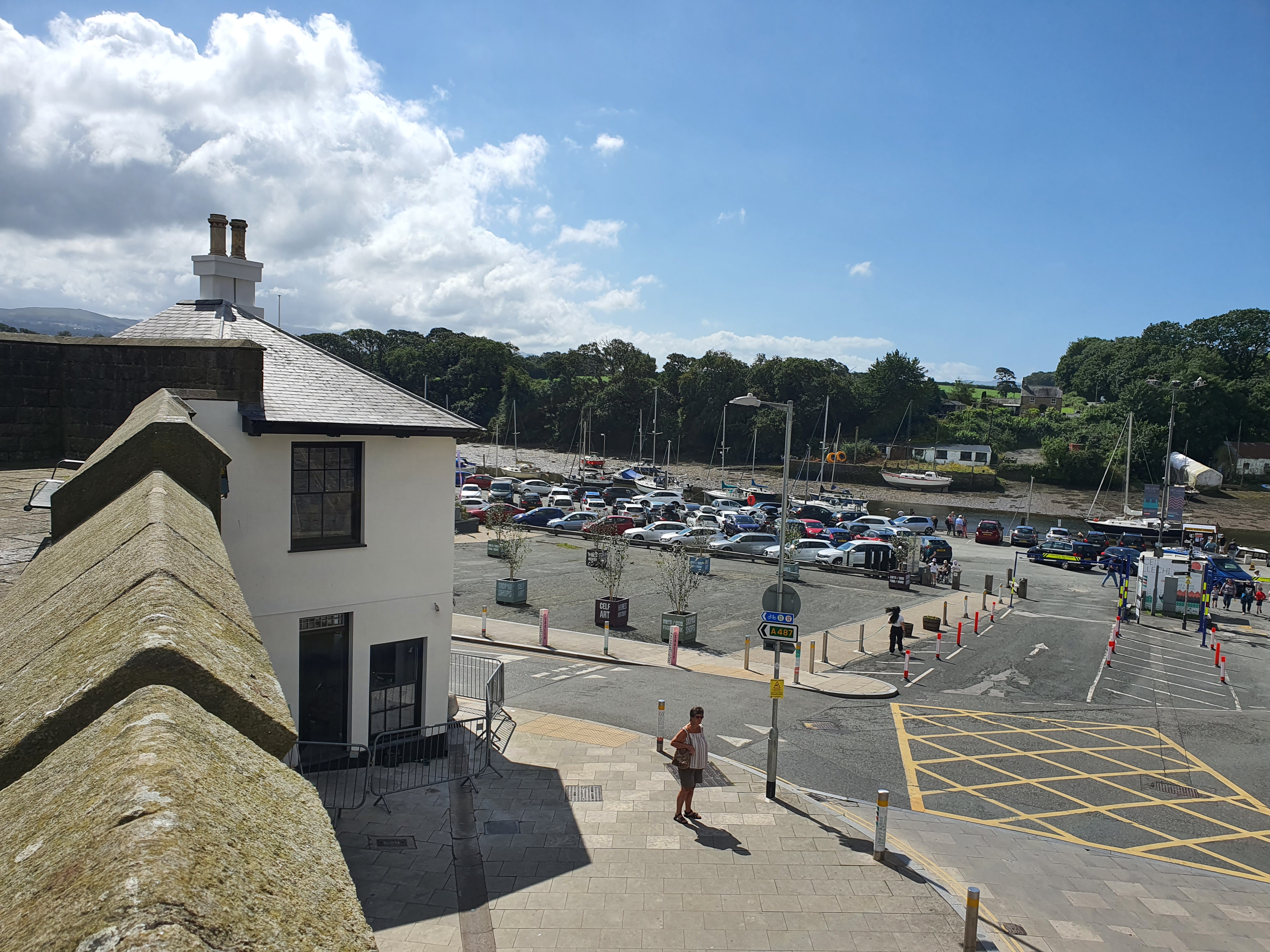 A coastal town with a car park, a small building, and a river in the background.
