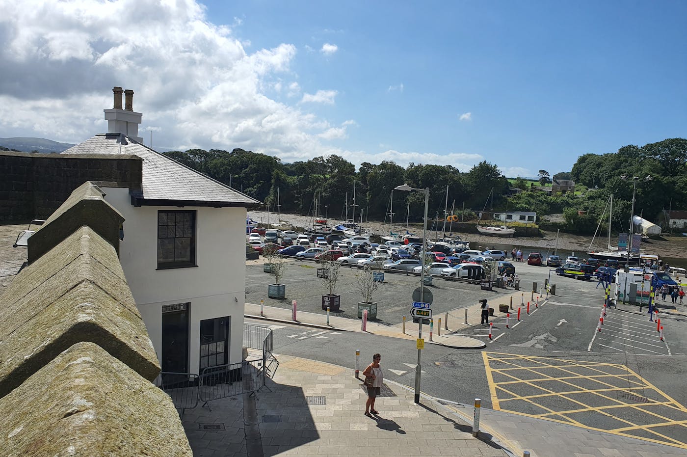 A coastal town with a car park, a small building, and a river in the background.