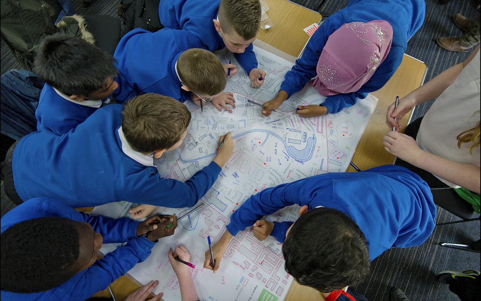 Children drawing over a map