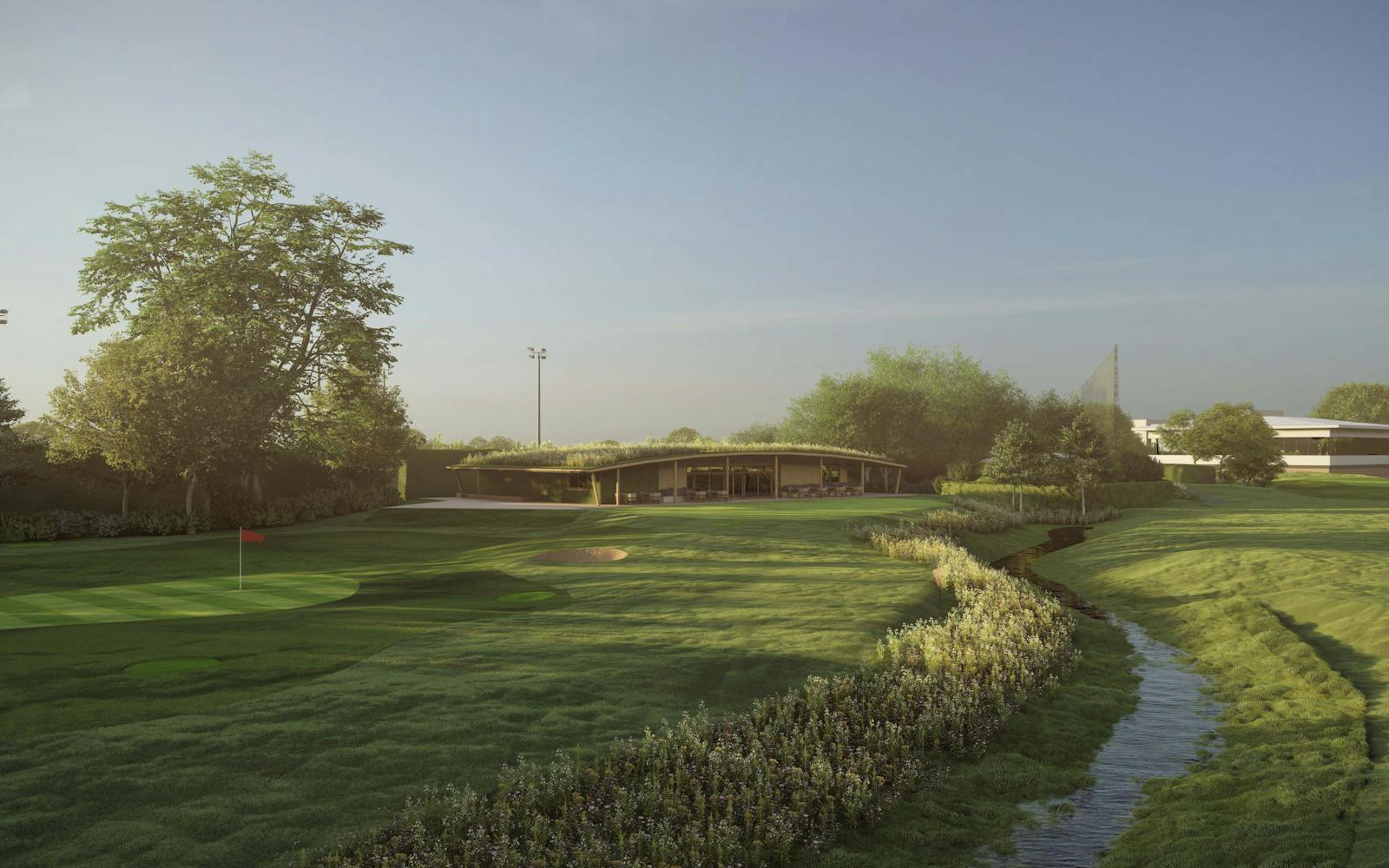 A modern, eco-friendly golf clubhouse with a curved, green roof nestled in a lush, green landscape. A small stream flows through the foreground, and a golf course with a flag is visible in the distance.