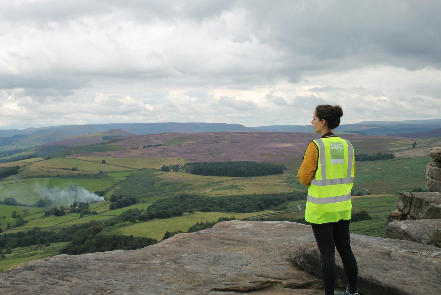 Person looking over hills, wearing hi-vis vest