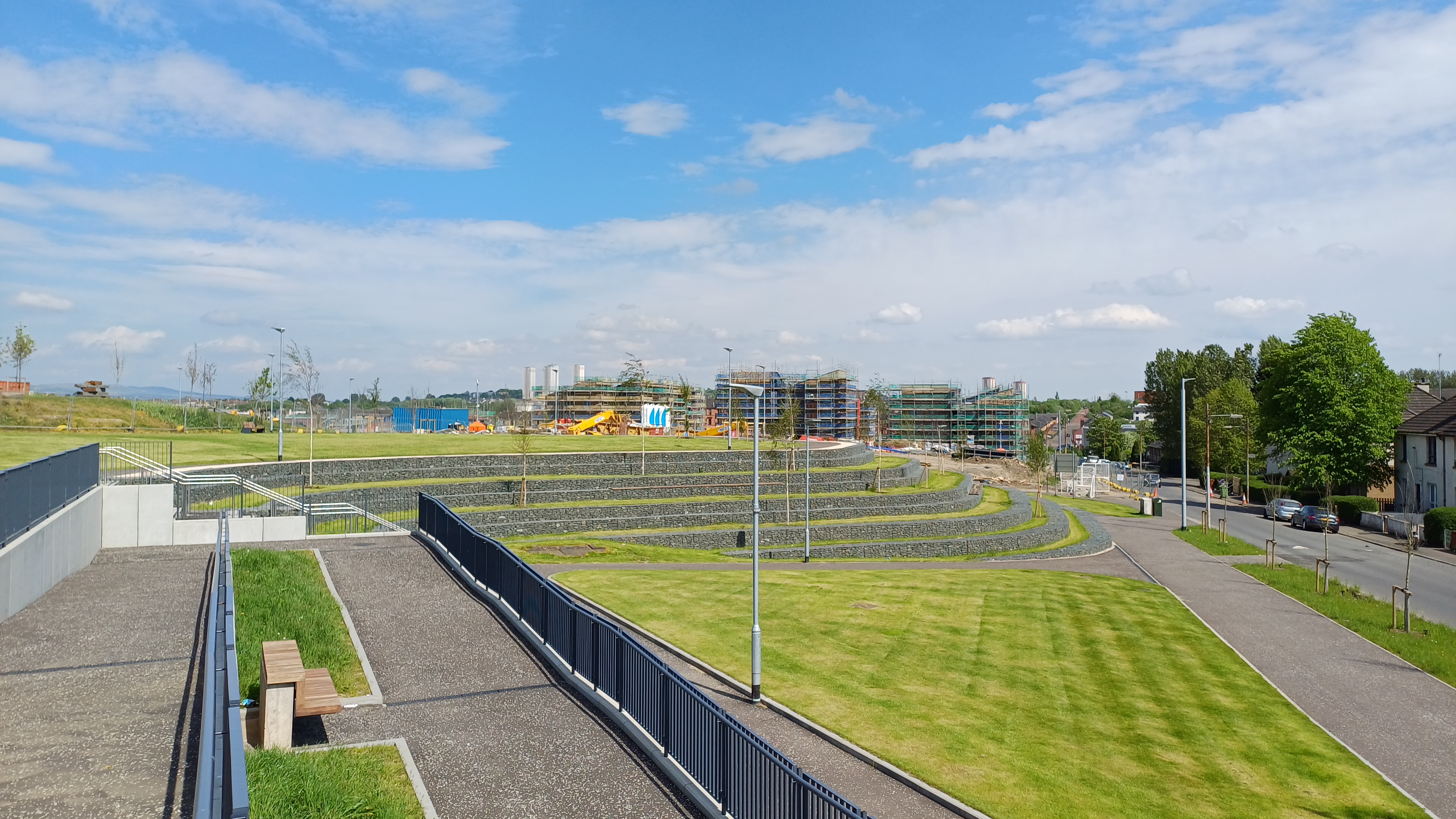a grassy park under a clear sky, with buildings in the background