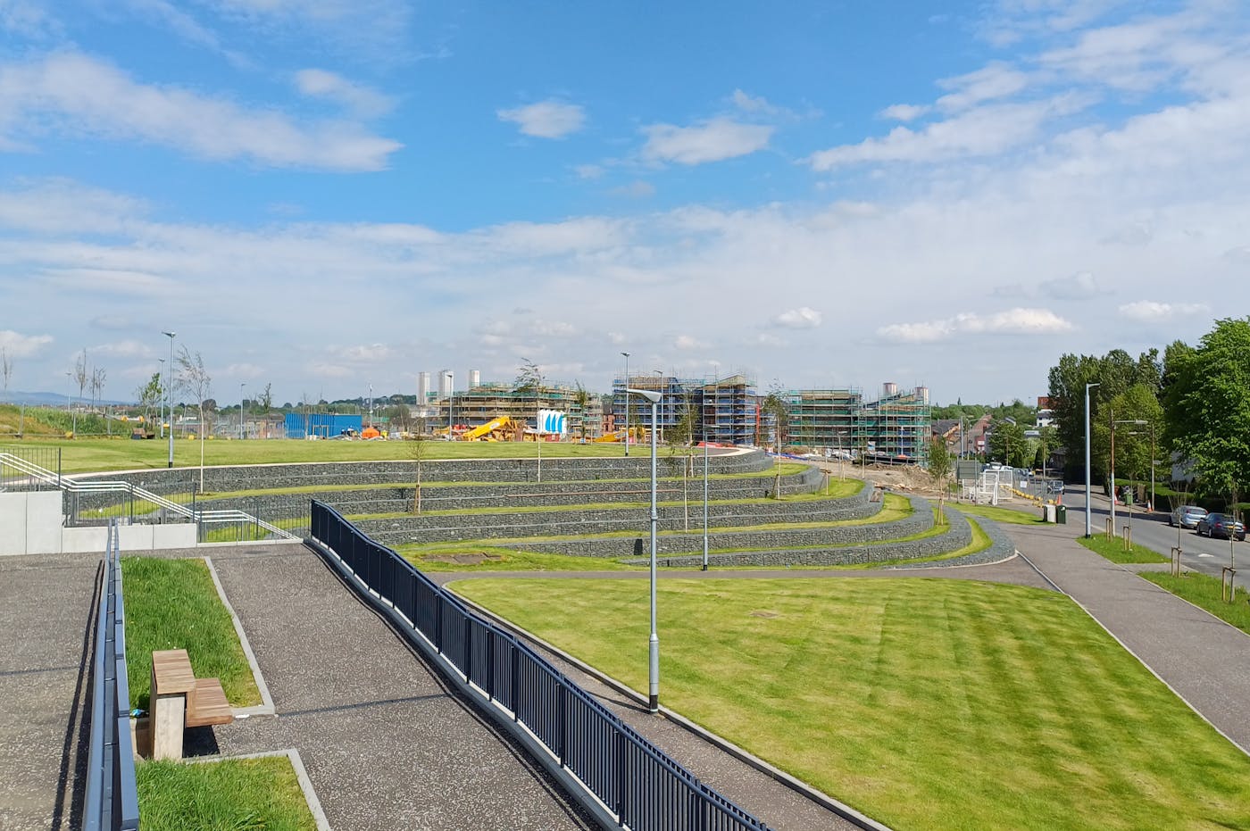 a grassy park under a clear sky, with buildings in the background
