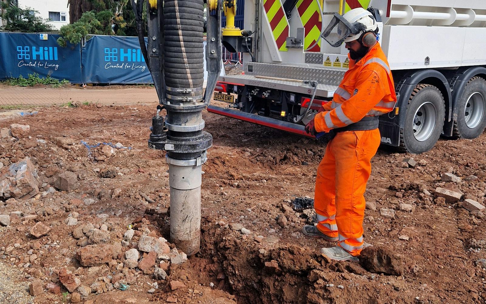A person in high-vis next to heavy plant machinery