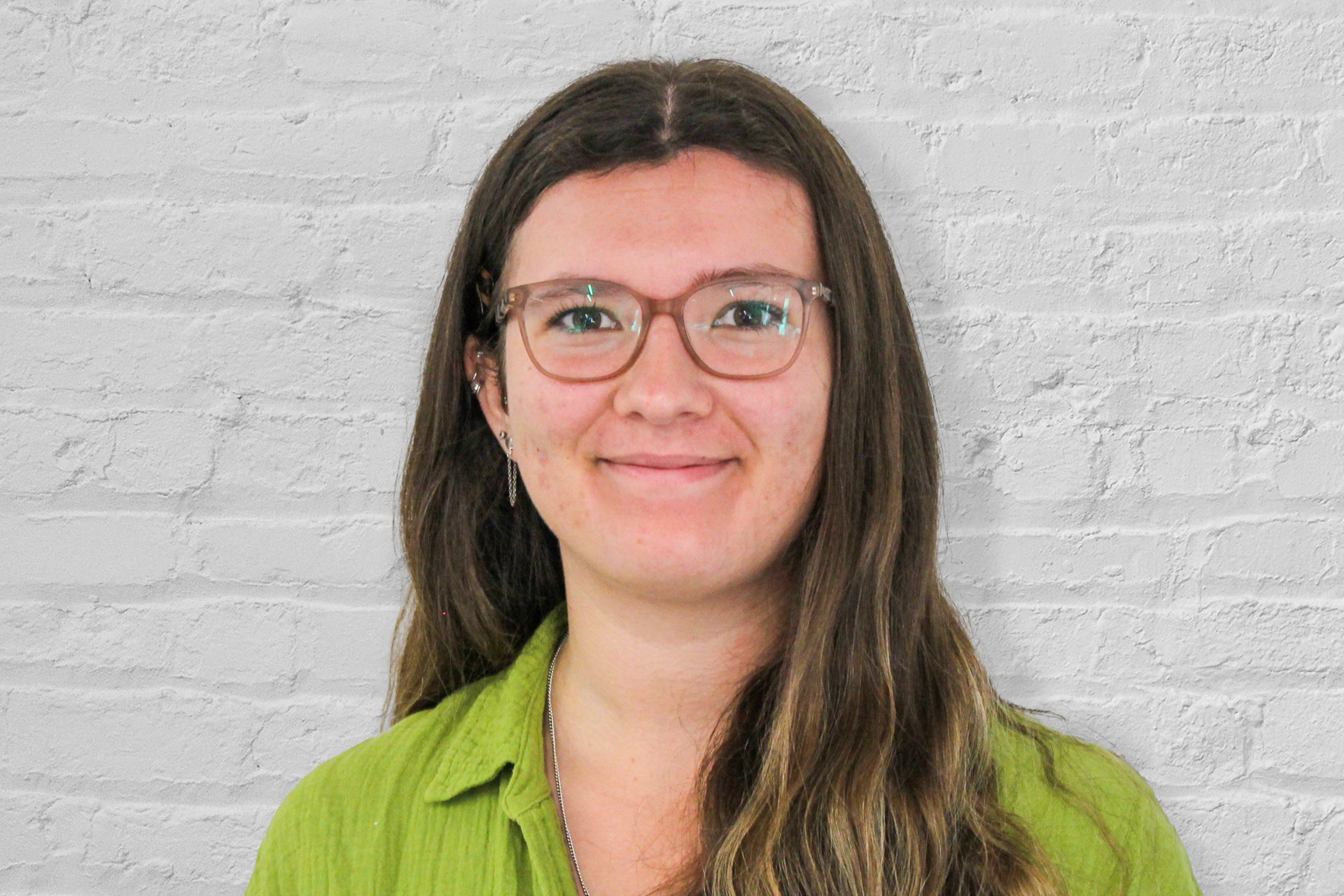 A person standing in front of a brick wall