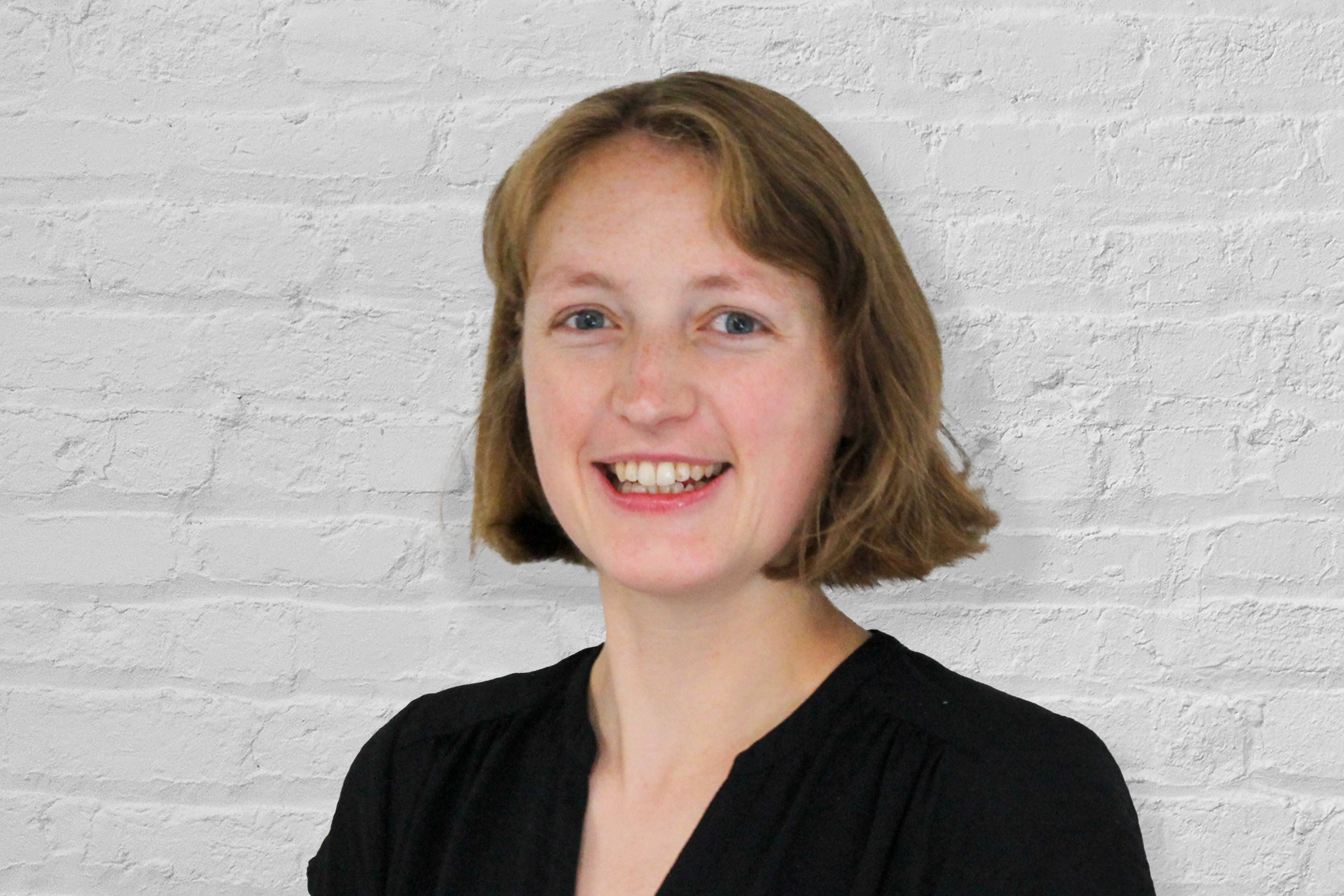 A person in front of a brick wall