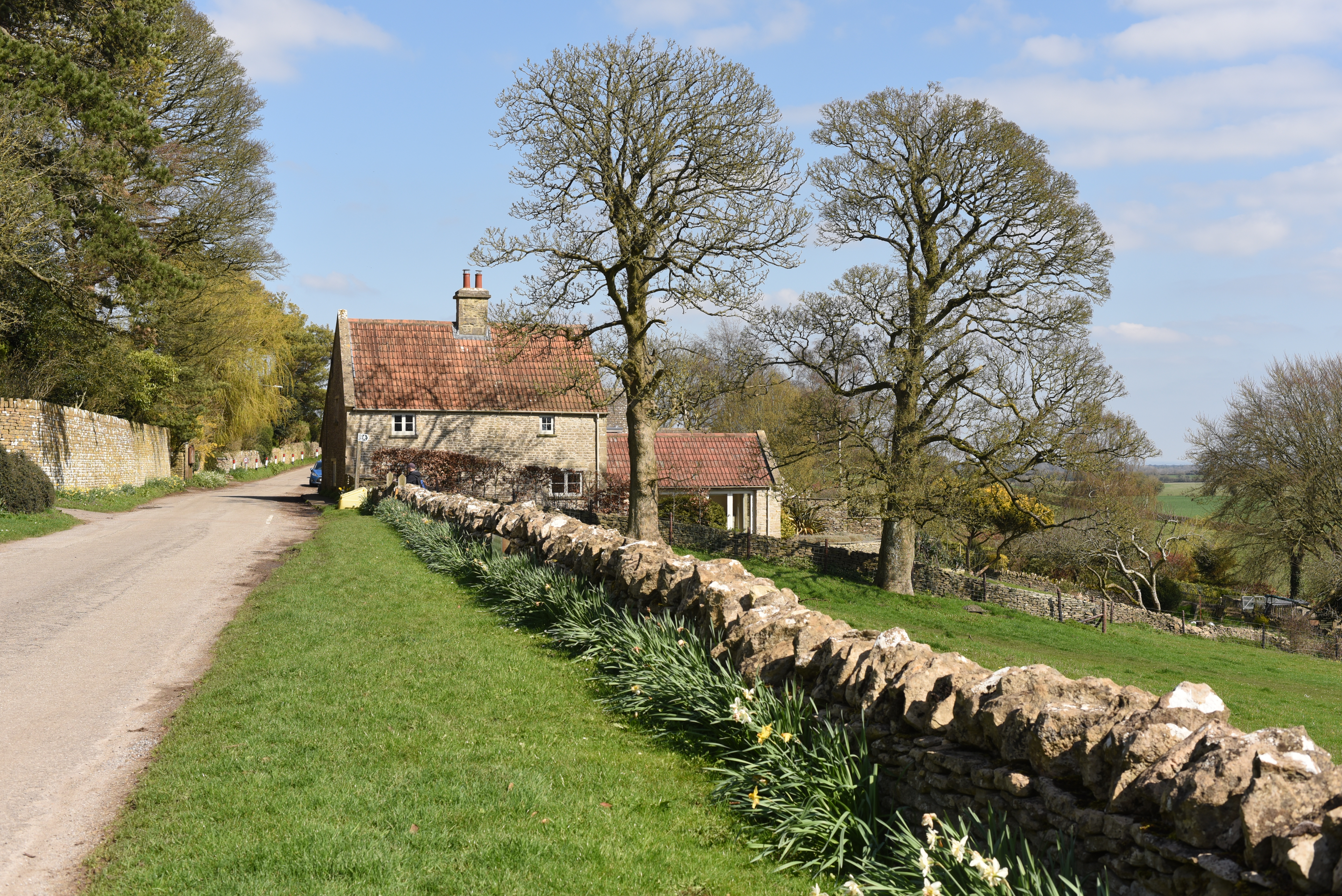 A cottage next to a road overlooking fields