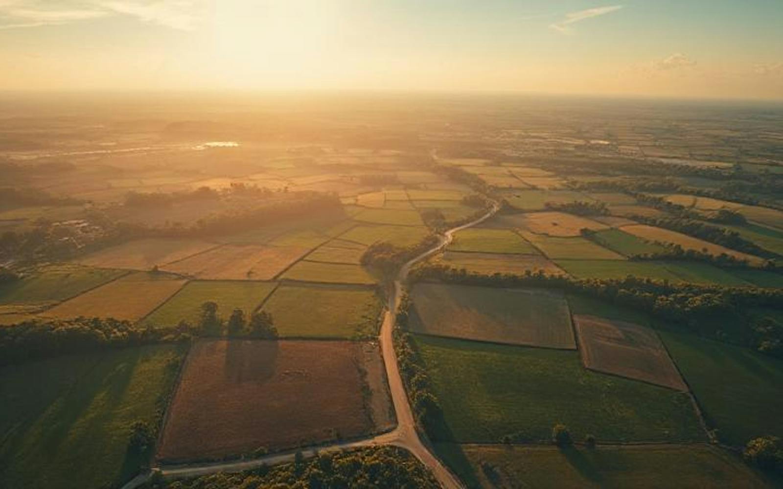 A landscape of fields with a sunset