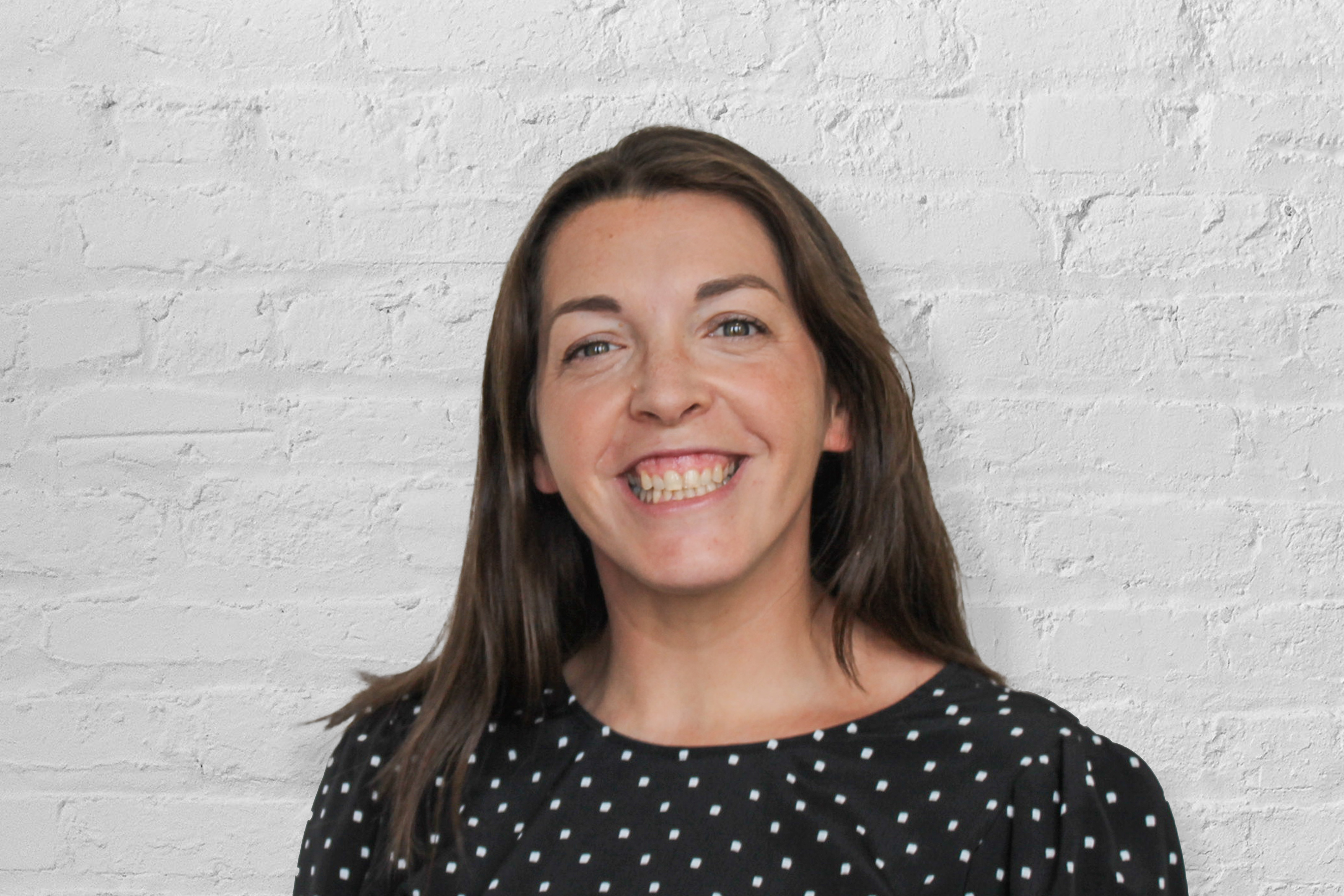 A person in front of a brick wall