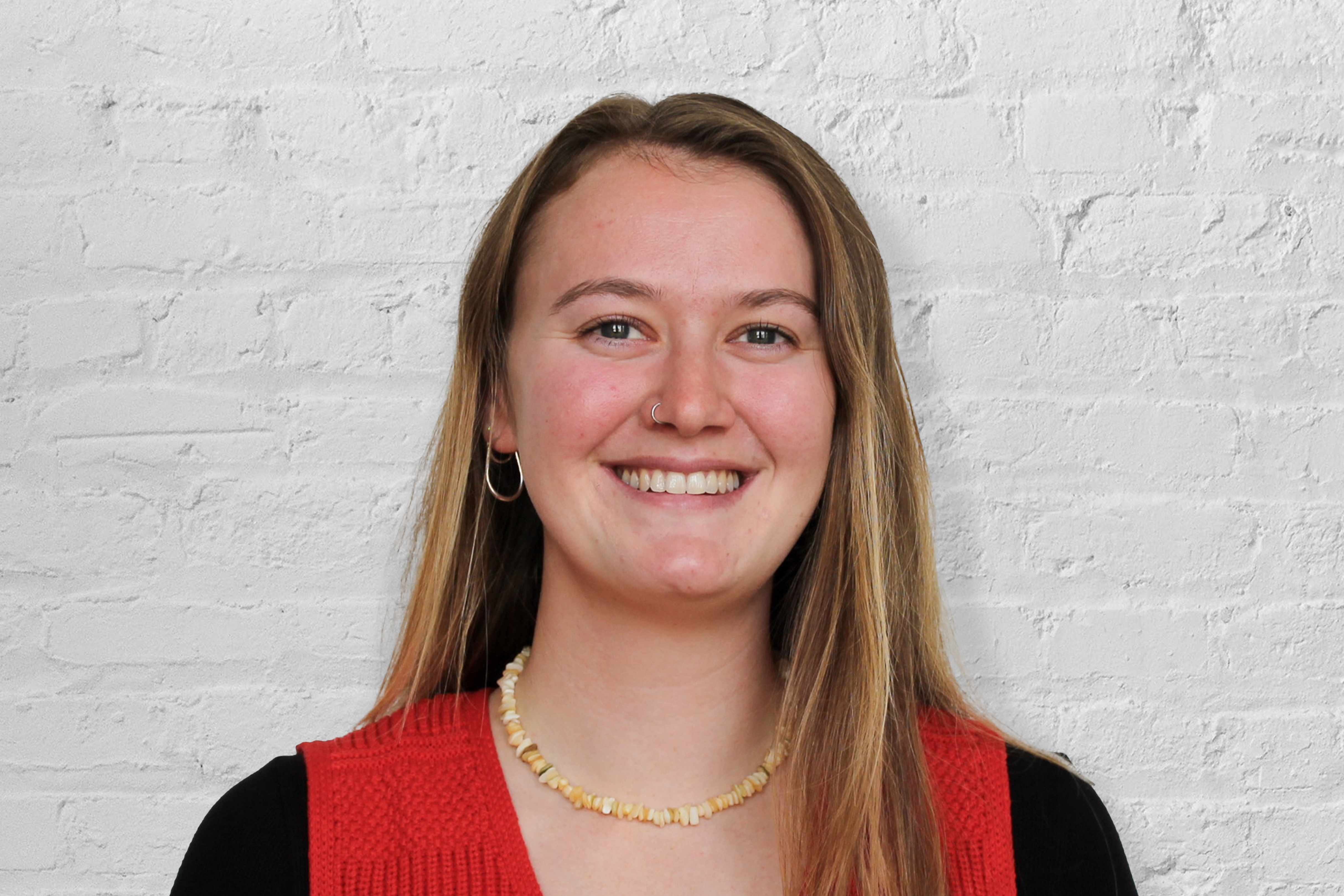 A person in front of a brick wall