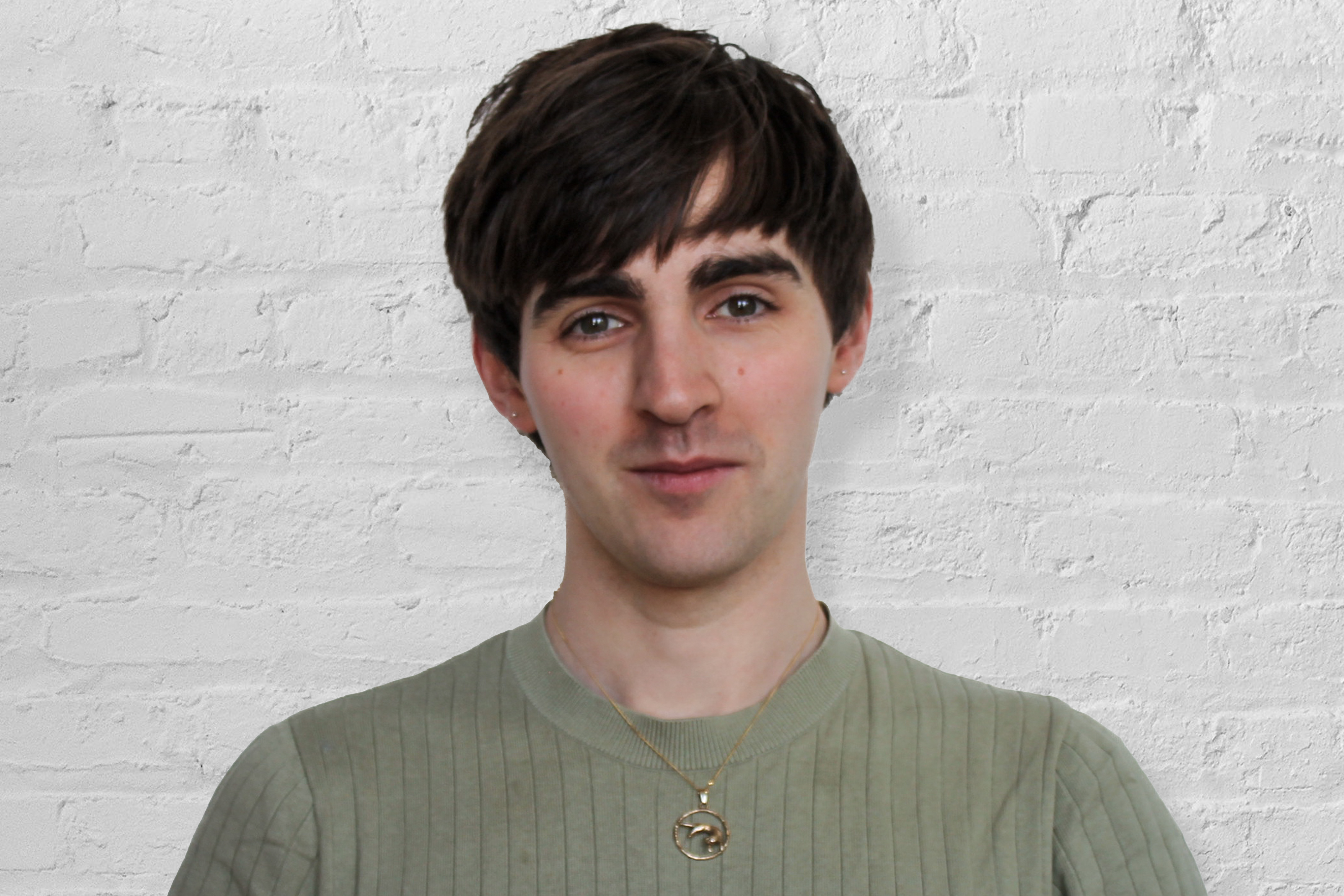 A person in front of a brick wall