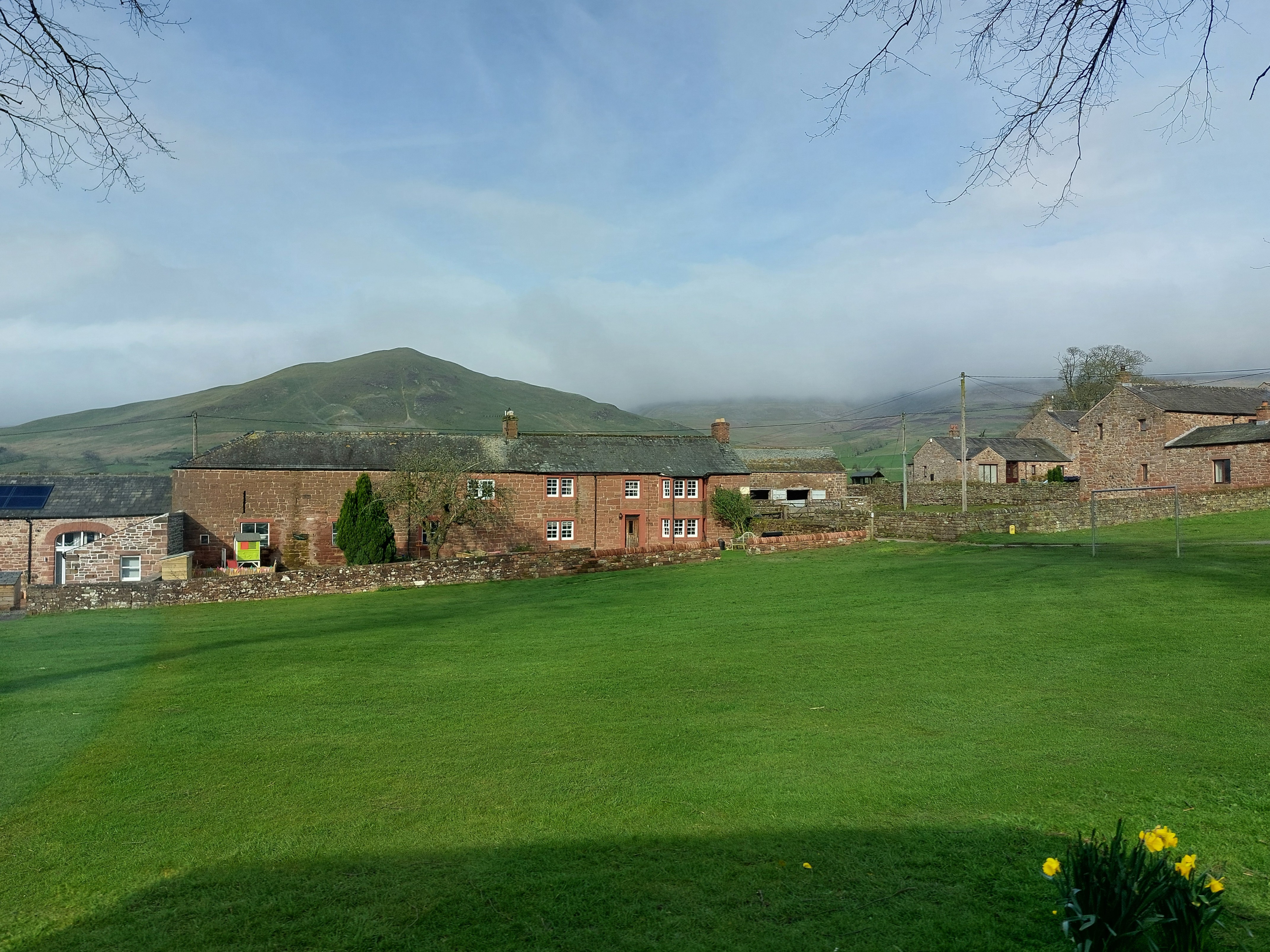 A scenic Welsh landscape with houses and mountains in the background