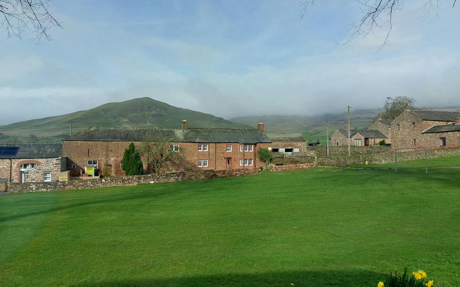 A scenic Welsh landscape with houses and mountains in the background