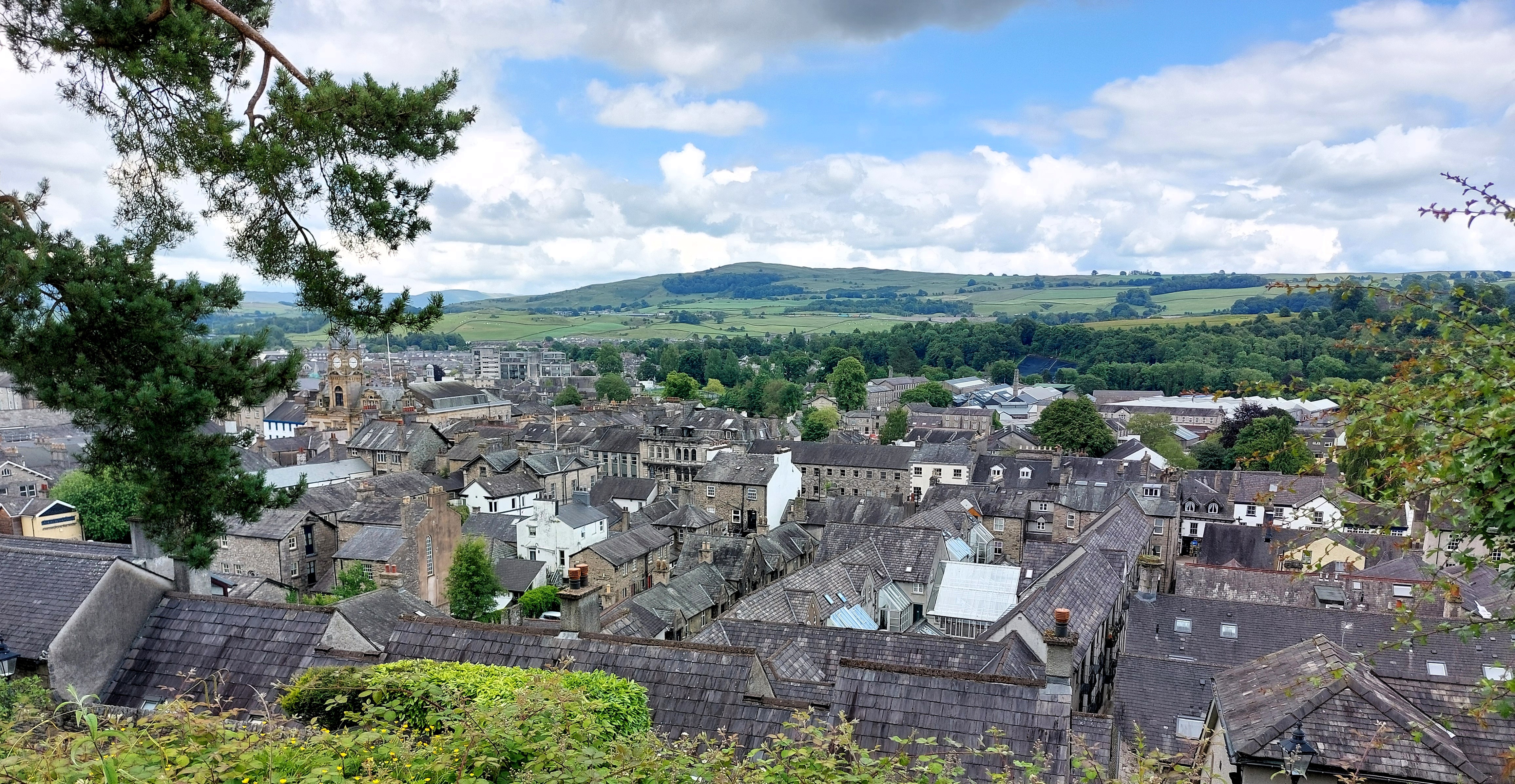 A view over grey rooftops and rolling English hills