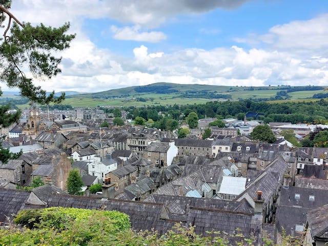 A view over grey rooftops and rolling English hills