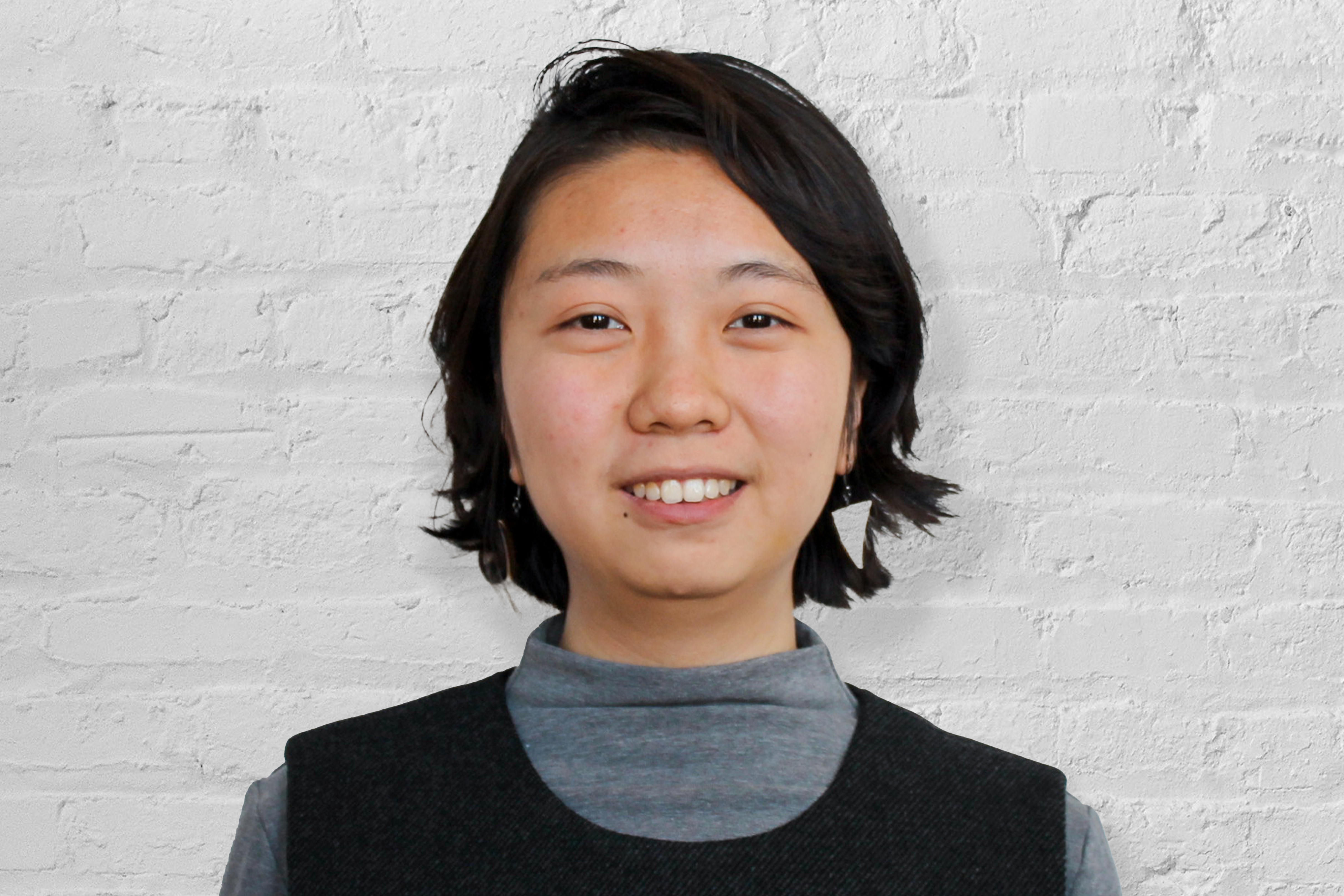 A person in front of a brick wall