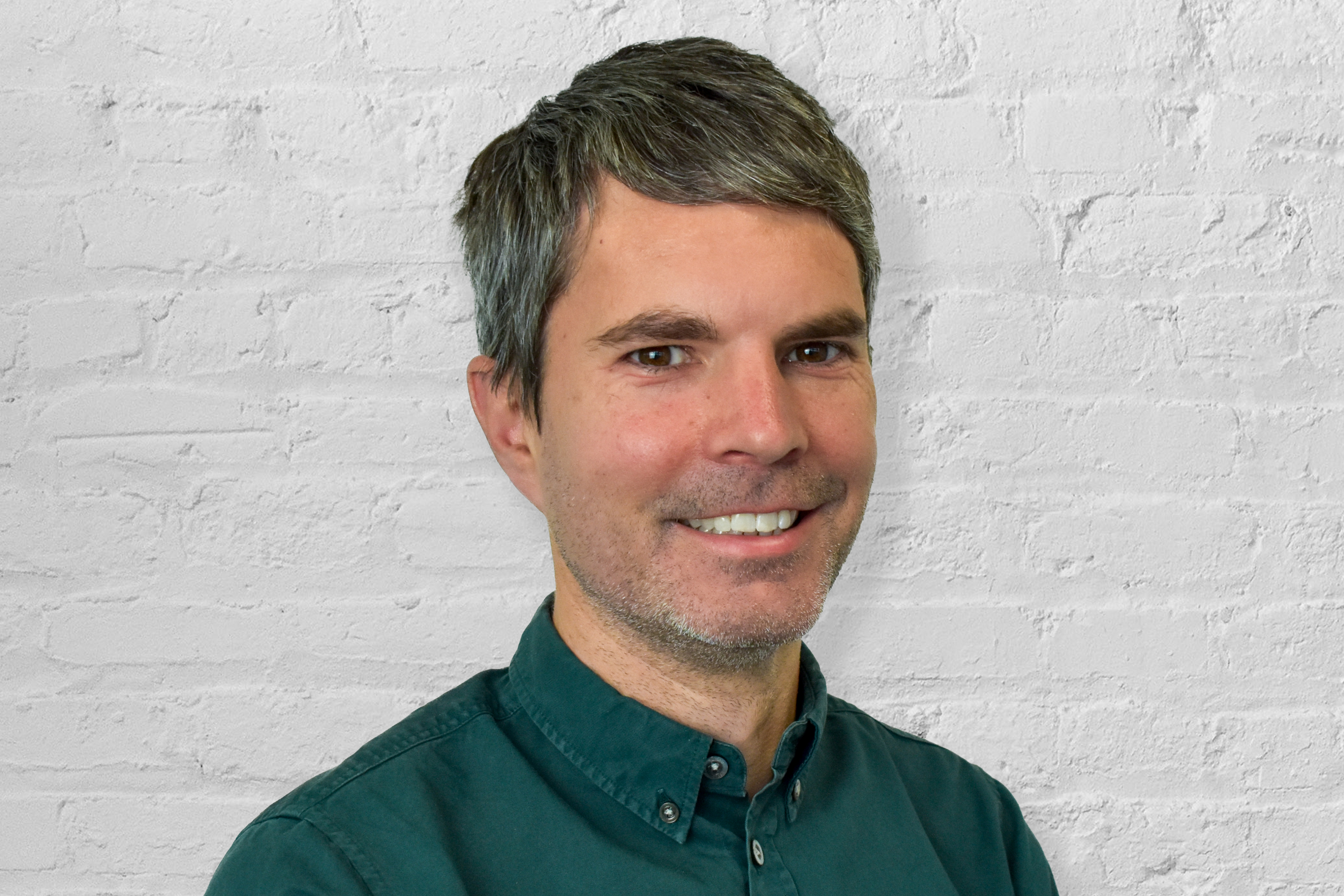 Person in front of white brick wall