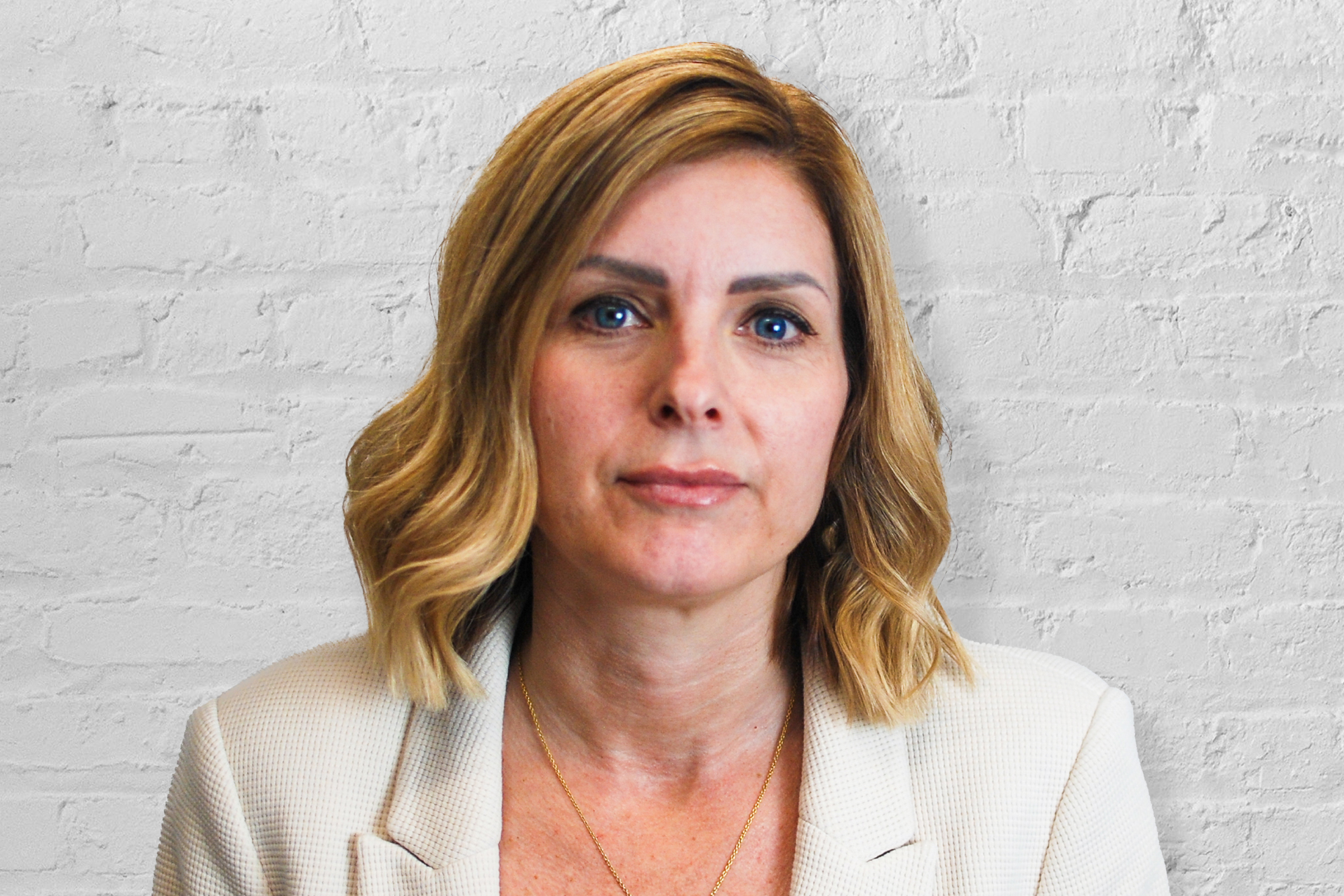 A person in front of a brick wall