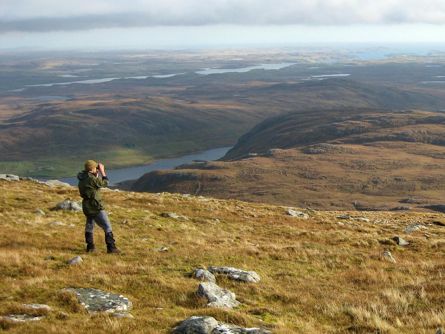 Man using binoculars in mountain landscape