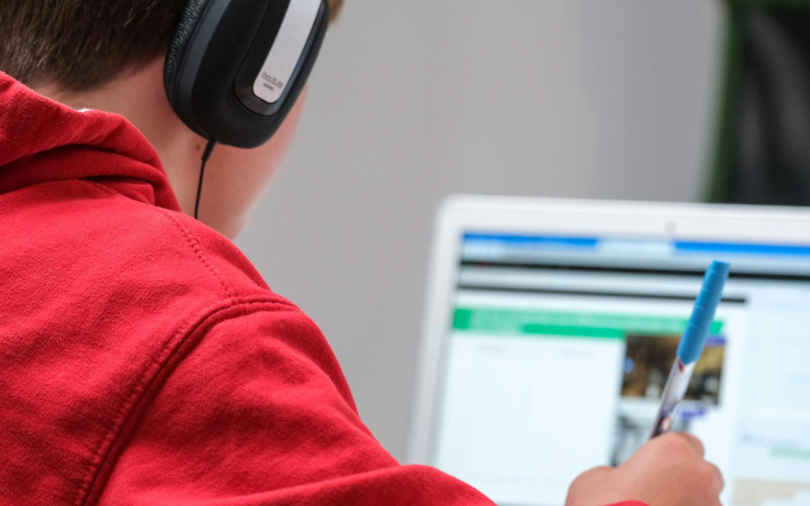 Person wearing headphones and using laptop