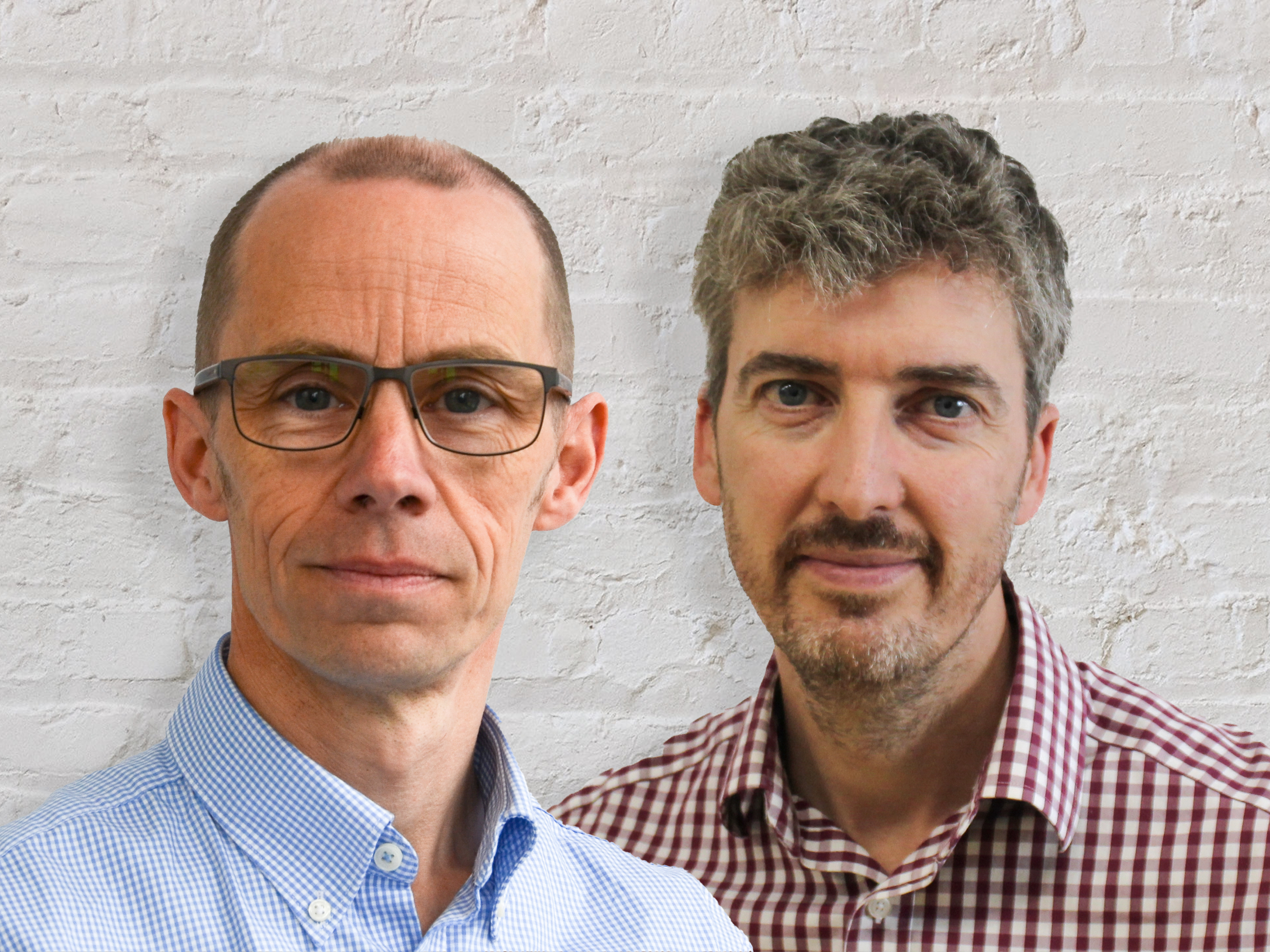 Two people in front of white brick wall