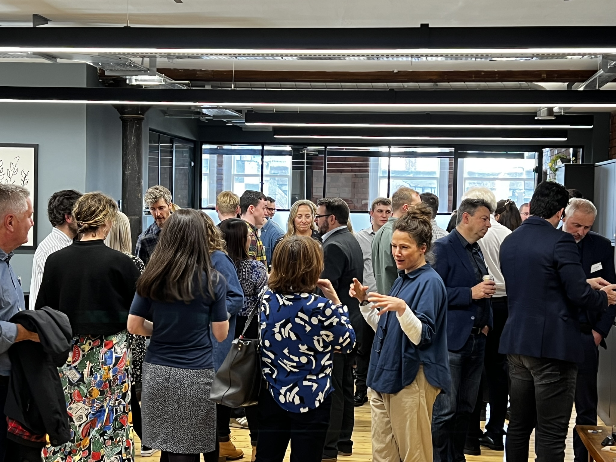 A crowd of people talking to each other 