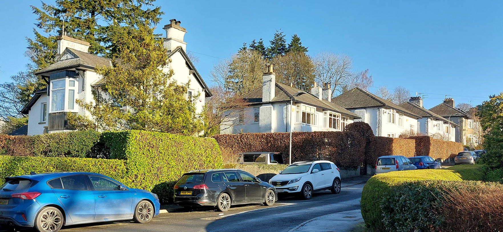 Cars on a road alongside houses 