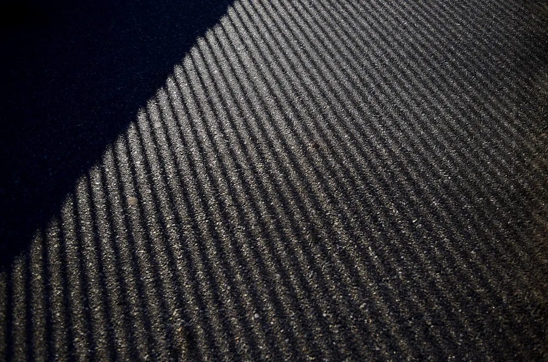 Close-up of a dark grey fire-retardant carpet in the sunlight